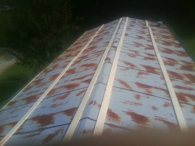 Rusted metal roof panels with new wood purlins before replacement — Storm Damage Roof Repair in Colstrip by Roofing Brothers