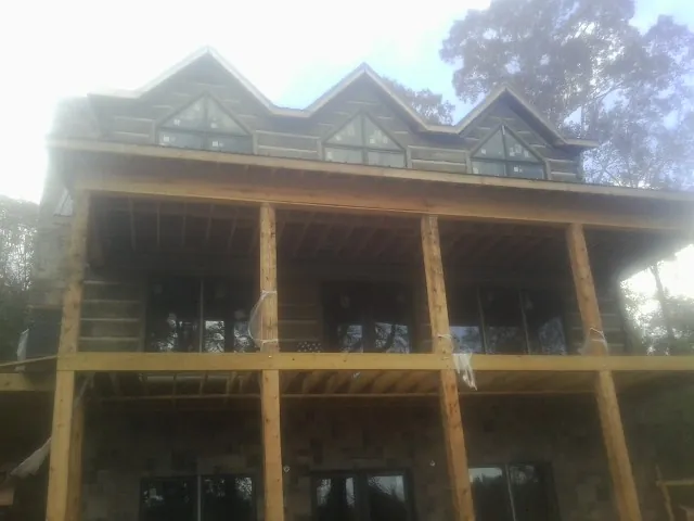 Dormers and porch framing on a large log home under construction — Roof Coating work by our crew in Colstrip