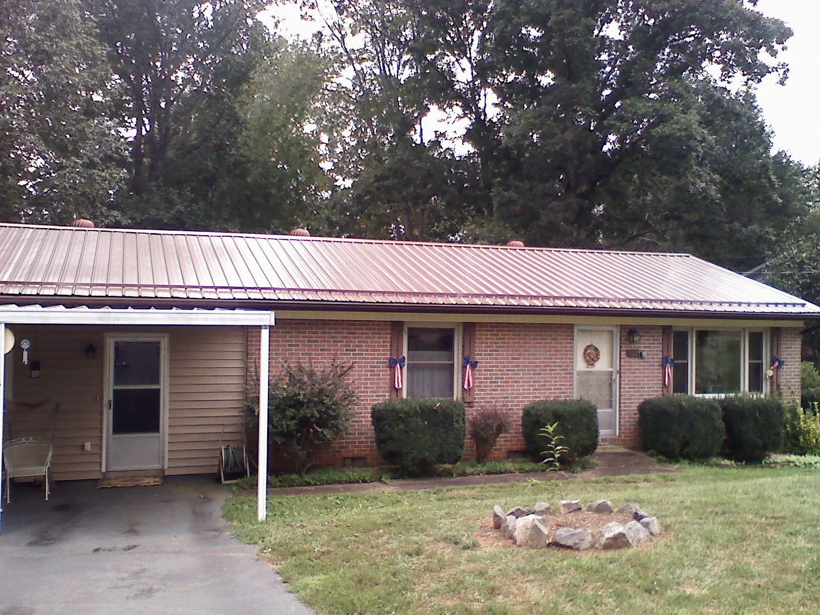 Bronze metal roof and carport on a brick ranch home — Roof Repair work by our crew in Colstrip